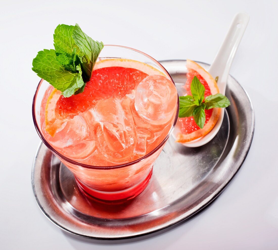 Grapefruit-Cocktail mit frischer Minze auf Silbertablett