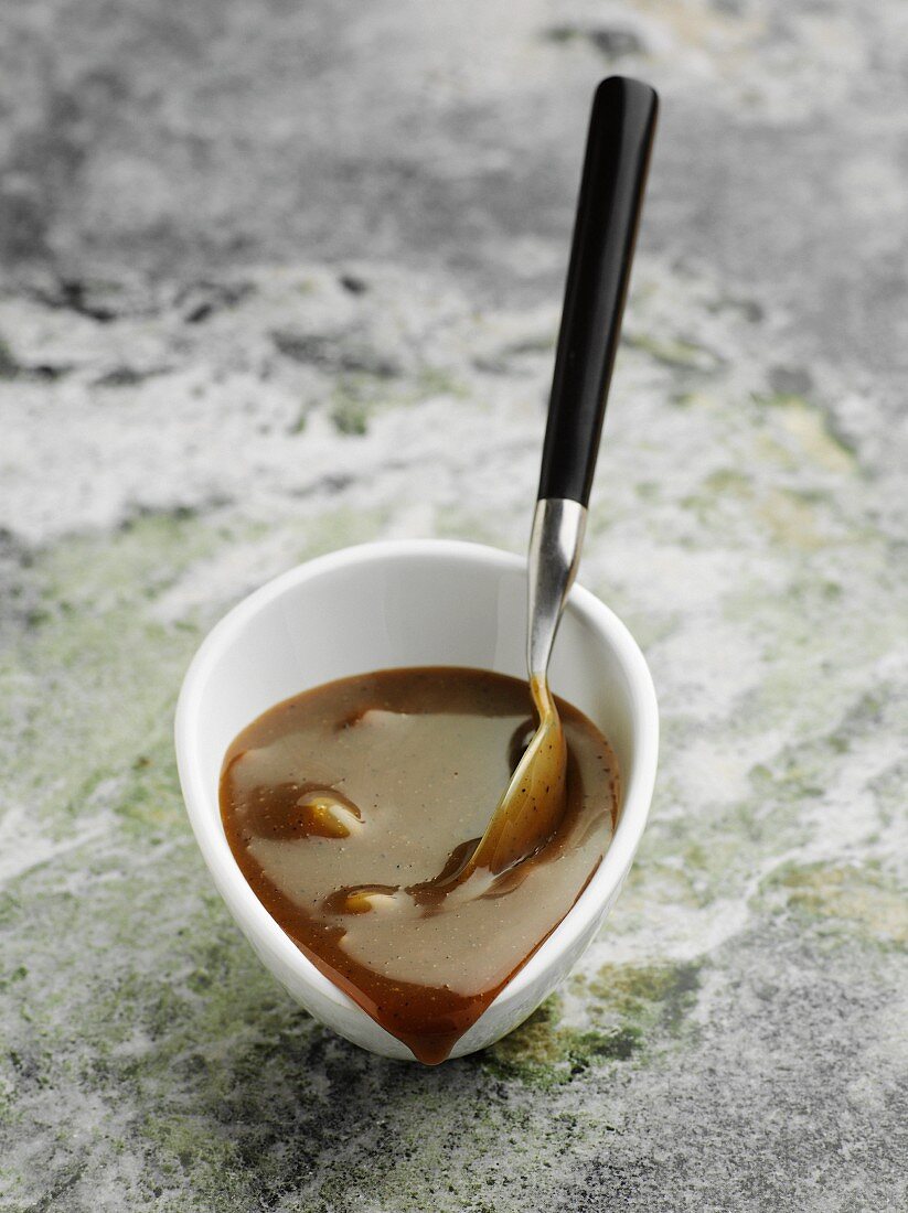 Liquorice sauce in a bowl with a spoon
