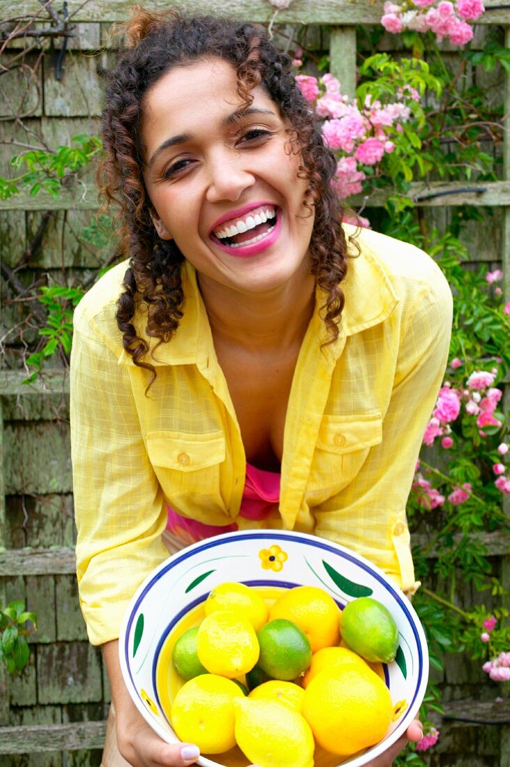 Portrait of woman holding bowl of lemons