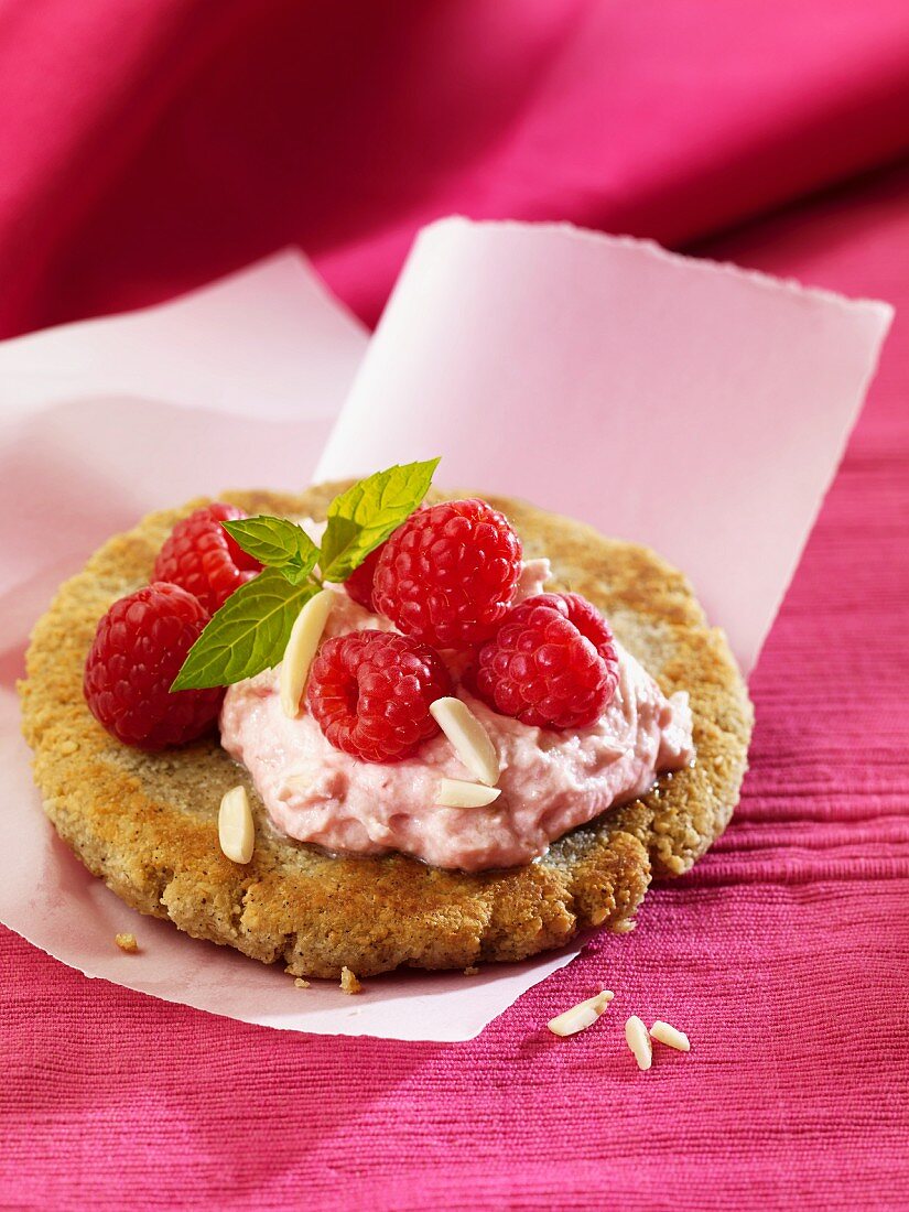 Pancake topped with raspberry cream and slivered almonds