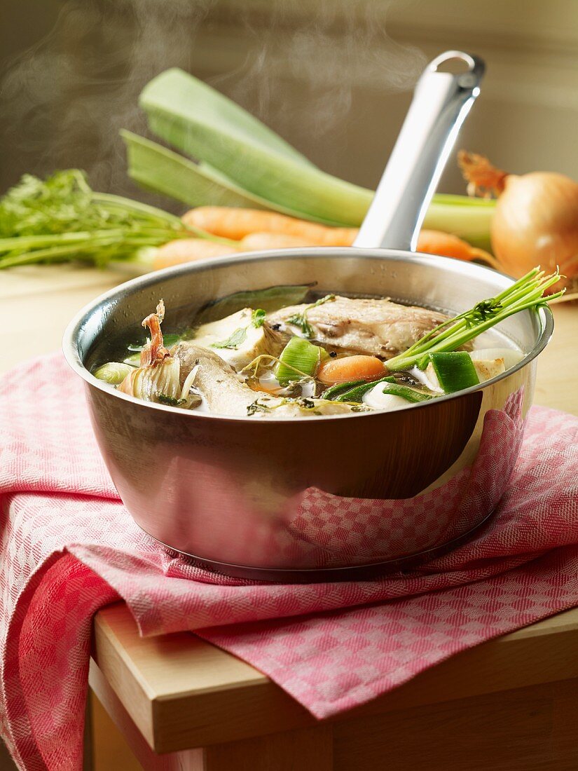 Chicken stock with vegetables in a saucepan