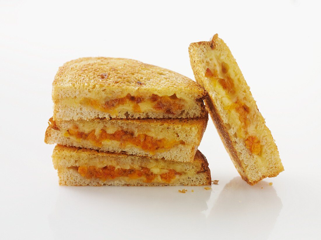 Toasted sandwiches, stacked, against a white background