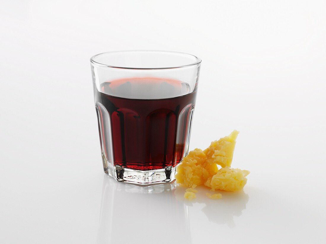 A glass of red wine against a white background