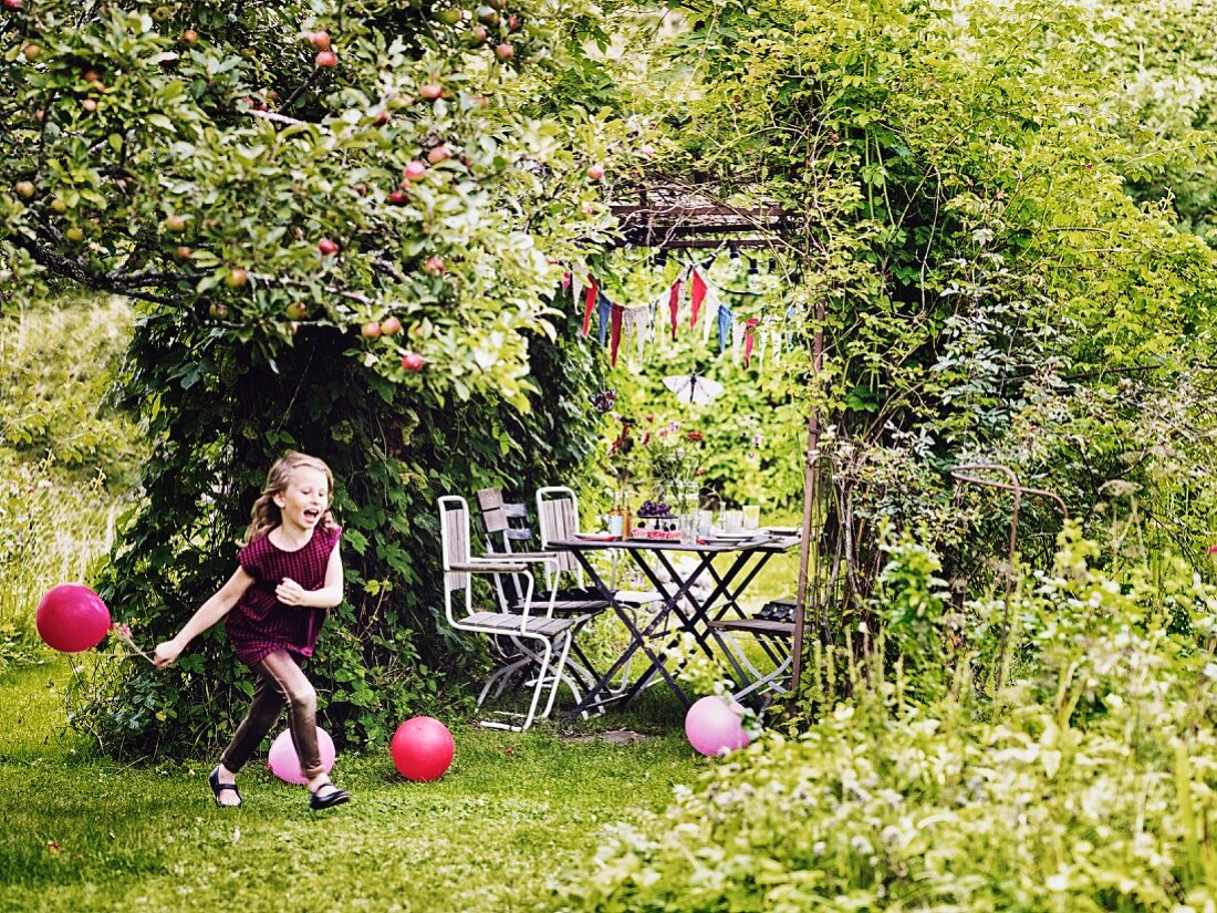 Mädchen mit Luftballon bei Kinderparty im Garten