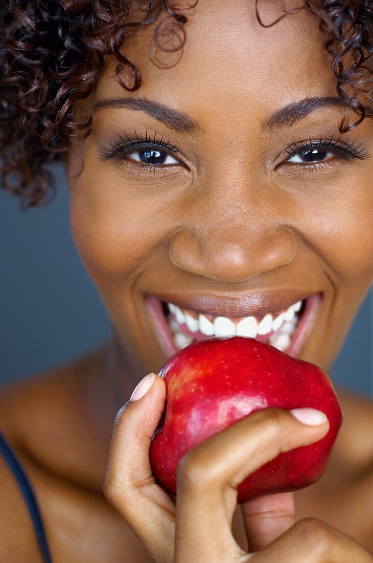 Close up of African woman eating apple