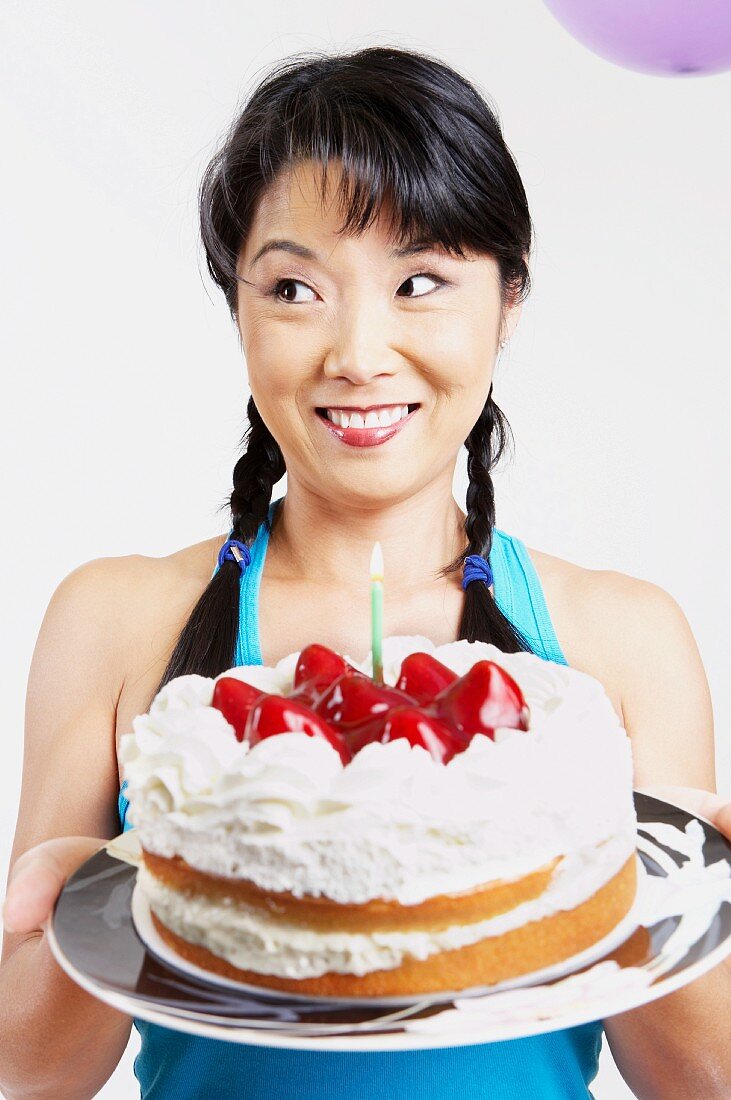Asiatische Frau mit Geburtstagstorte