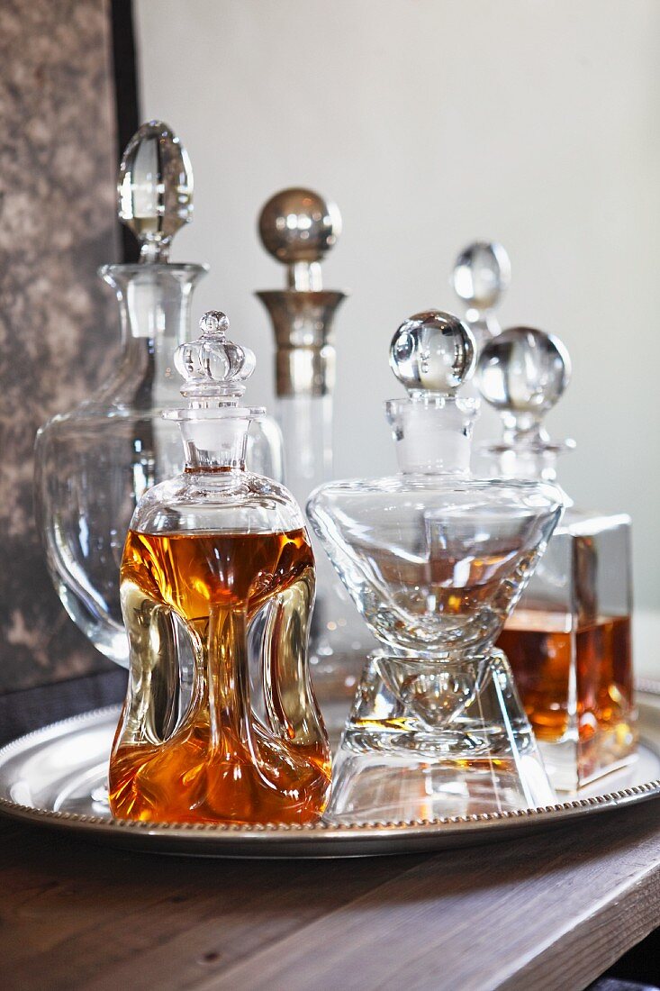 Crystal carafes with spherical stoppers on silver tray