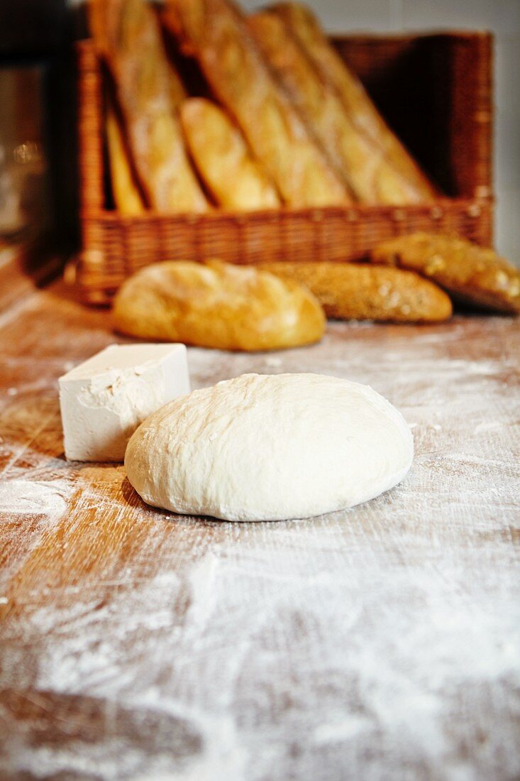 Unbaked bread and yeast, baked white loaves and baguettes