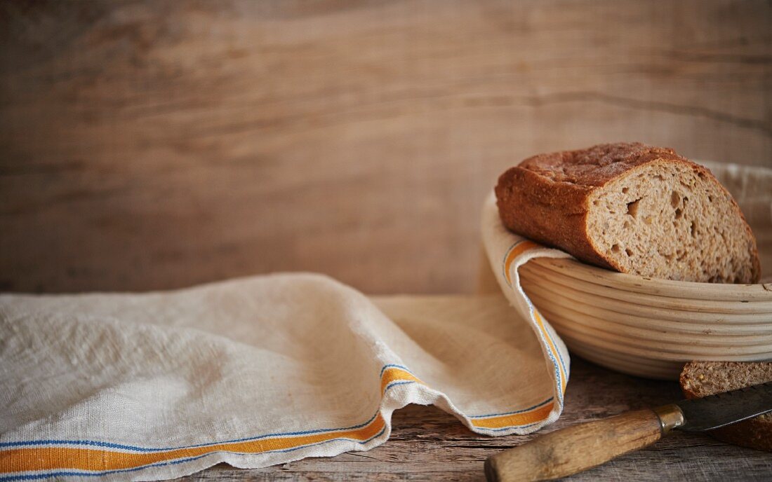 Frisches Brot in der Backform auf Holztisch mit Tuch