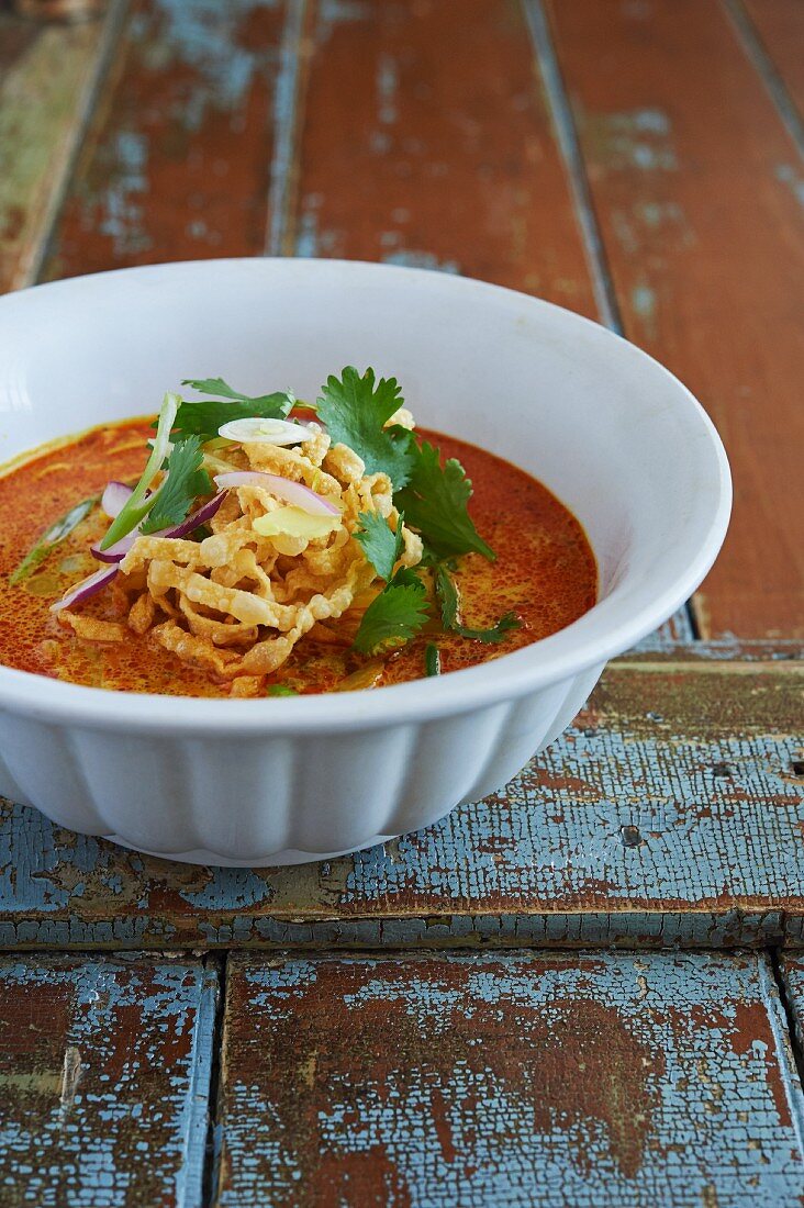 Thai Khao Soi Noodle Soup. made with egg noodles, coconut milk, yellow curry, cilantro, red and green onion, and crispy fried noodles.
