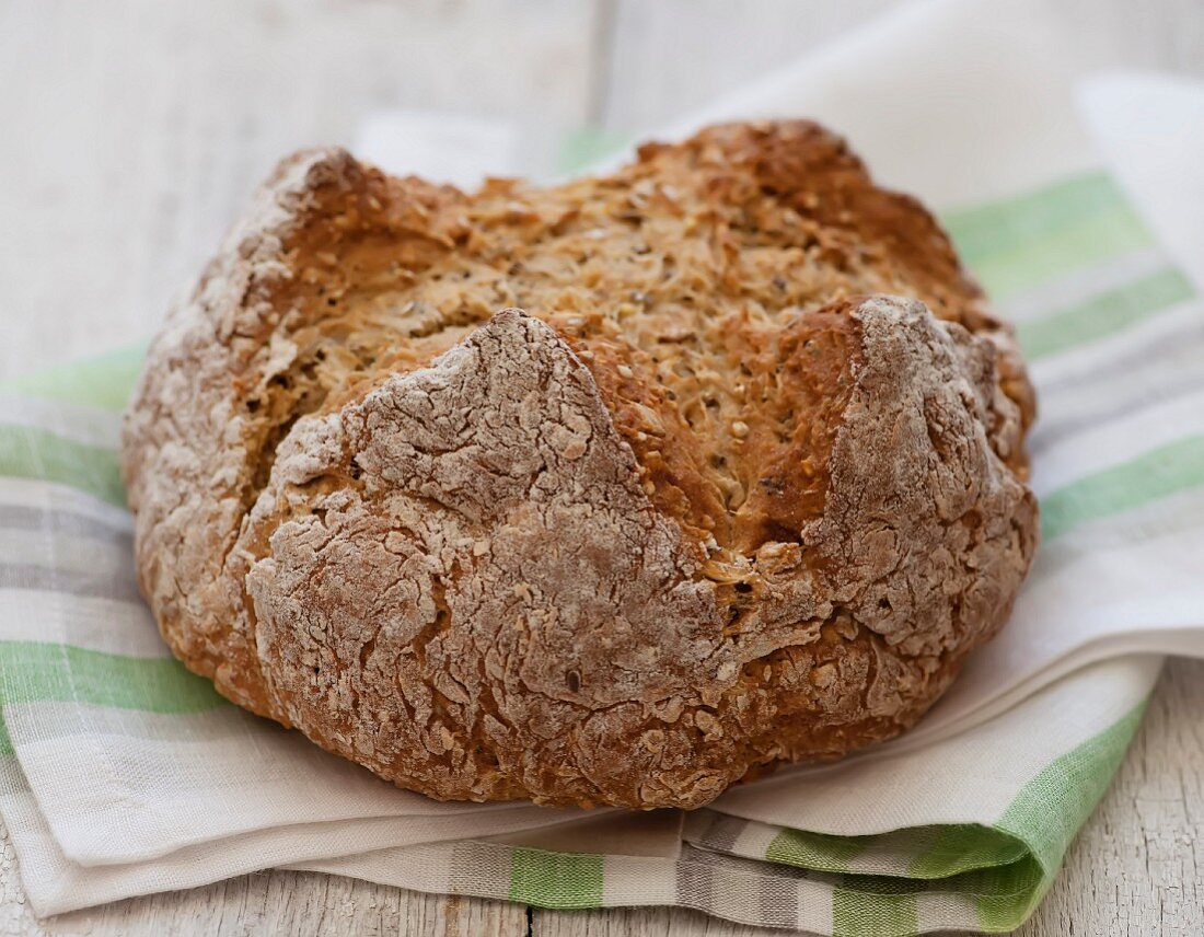 Rustikales Brot auf gestreiftem Tuch – Bilder kaufen – 11243059 StockFood