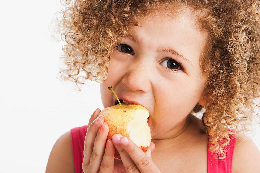 Mixed race girl eating apple