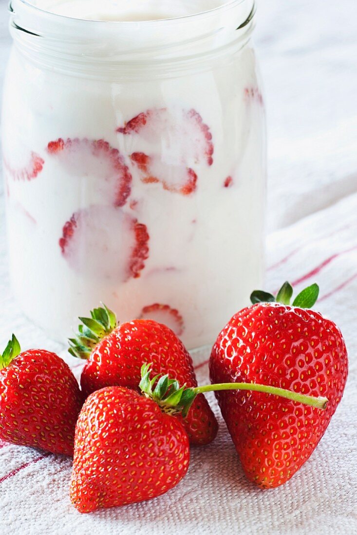 Plain yoghurt in a jar with fresh strawberries