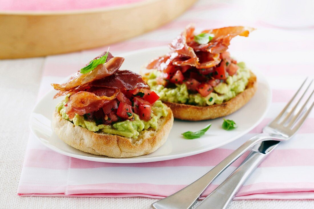 English muffins with avocado, tomatoes and prosciutto