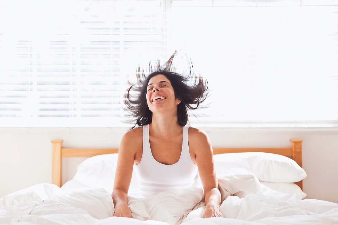 Woman sitting in bed smiling