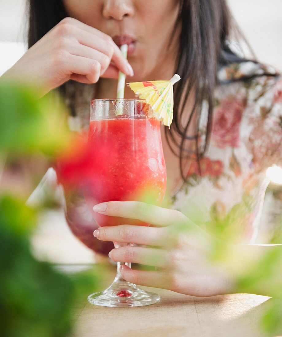Frau trinkt Tropic-Cocktail