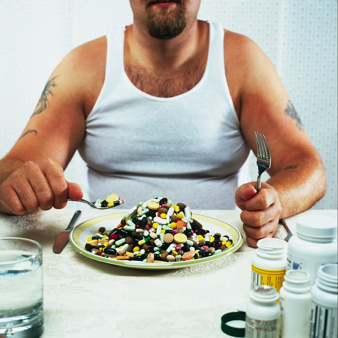 Overweight man eating plate full of pills