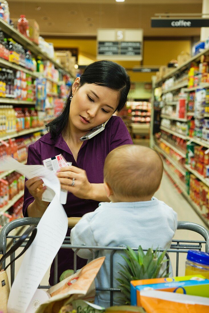 Asian woman reading list in grocery store