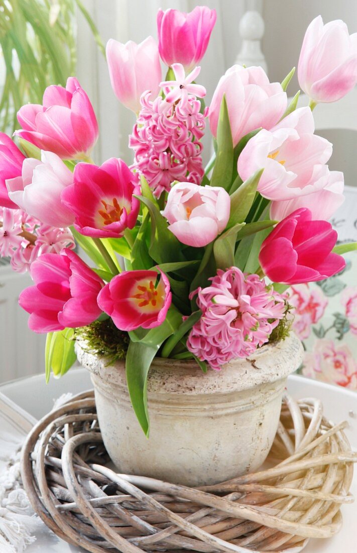 Stone container with a bouquet of tulips (Tulipa) and hyacinths (Hyacinthus)