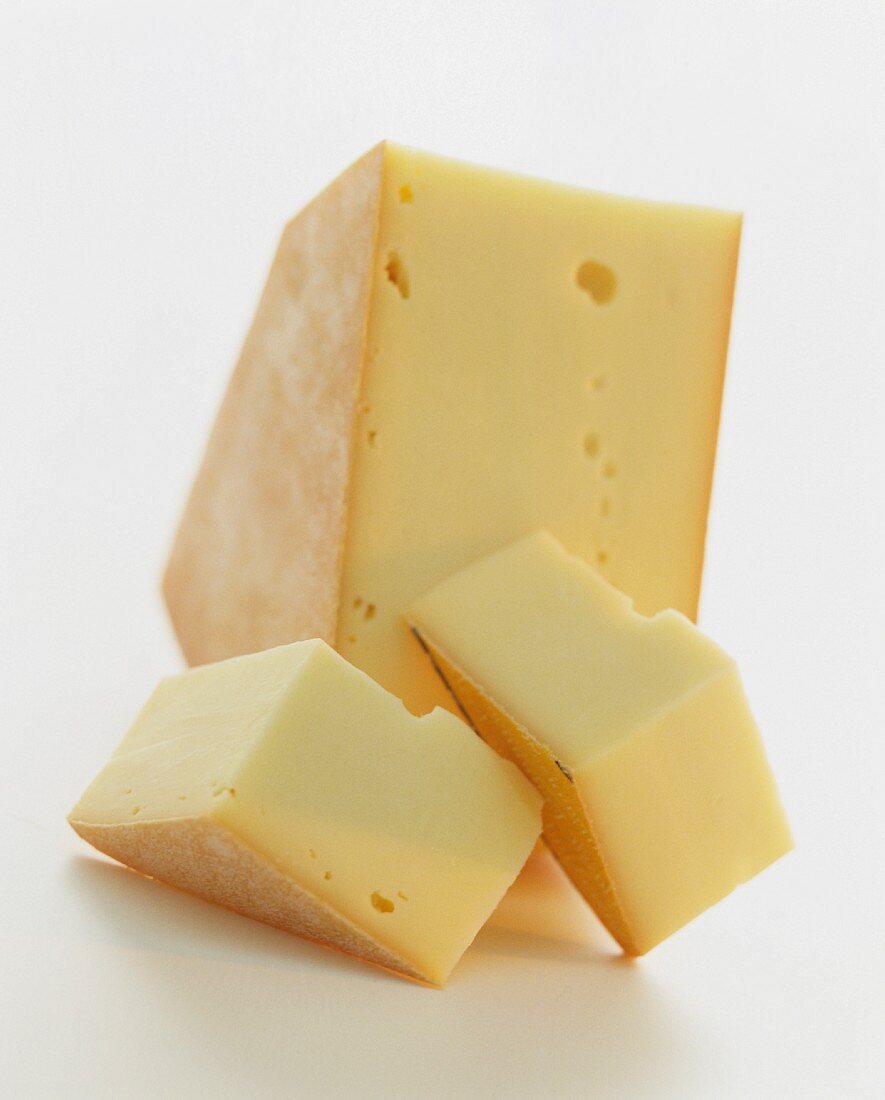 A wedge of Raclette cheese against a white background