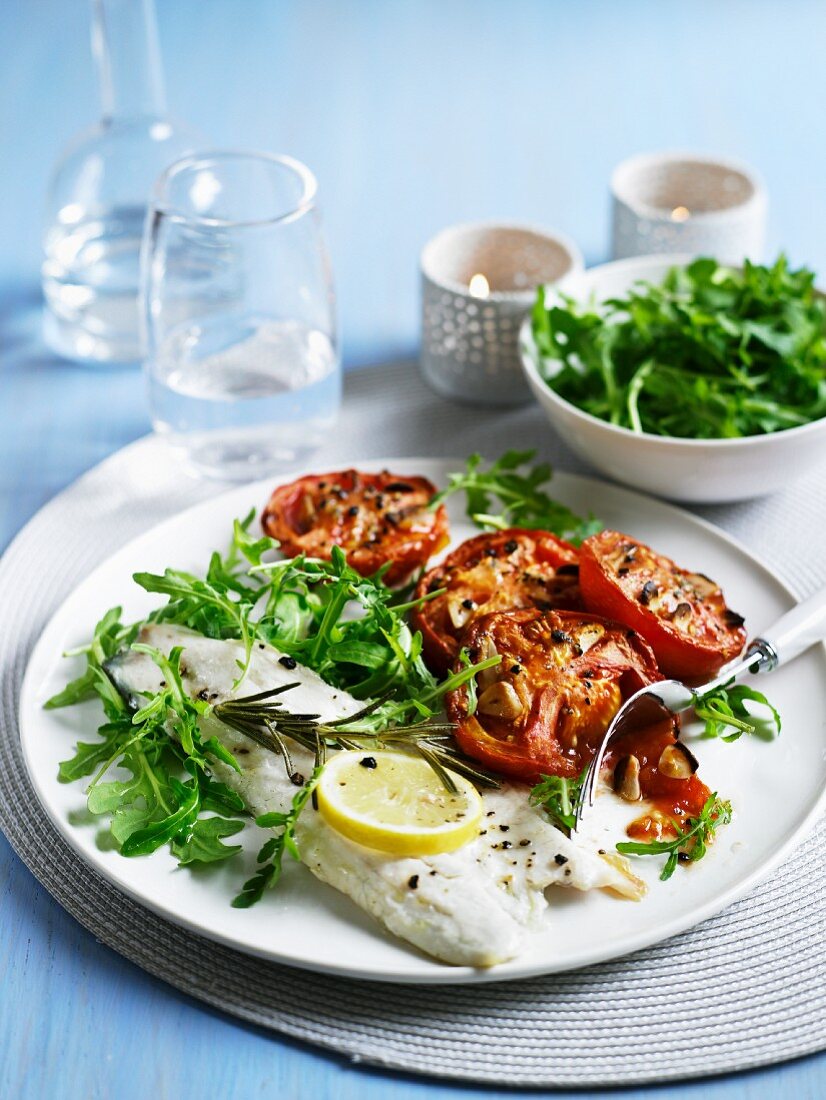 Baked sea bass with tomatoes and rocket