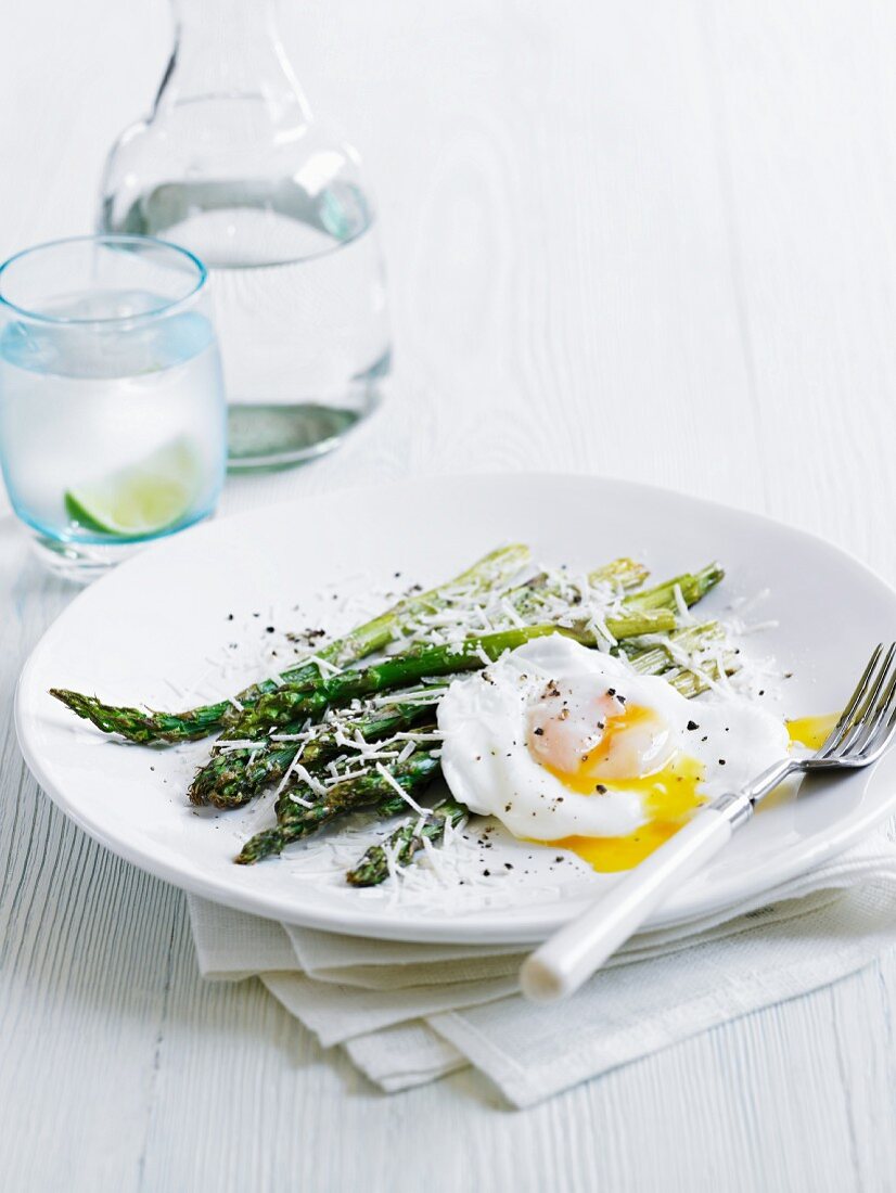 A poached egg with green asparagus and parmesan