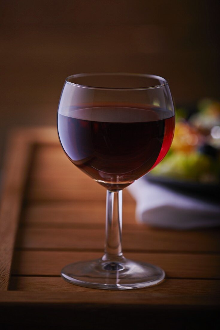 A glass of red wine on a wooden table
