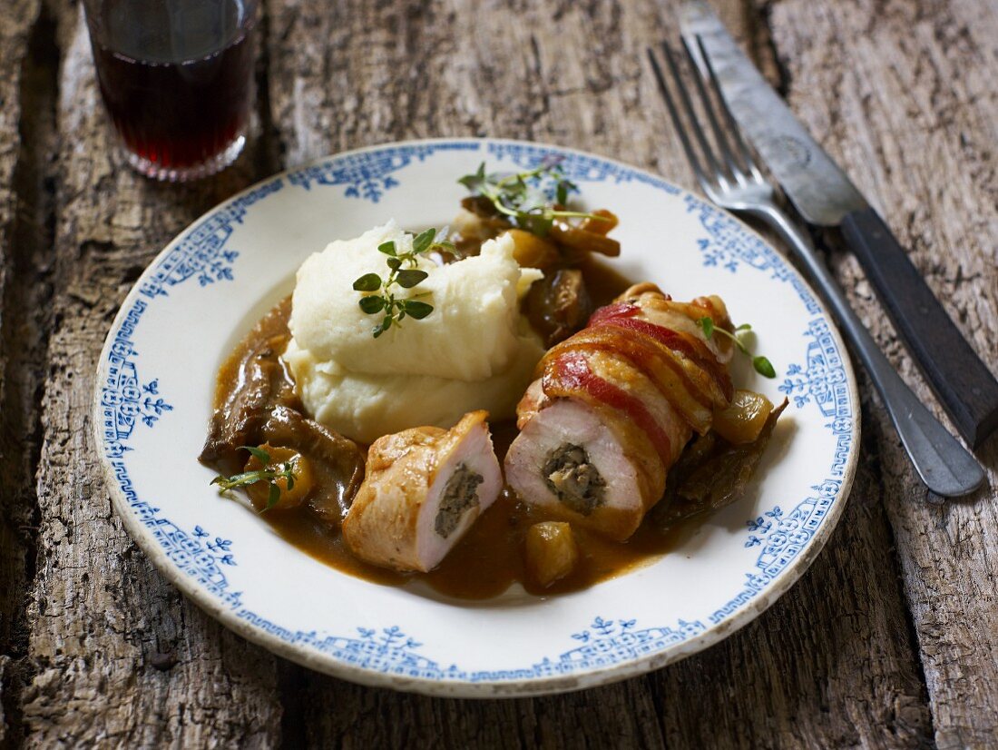 Stuffed rolled chicken breasts wrapped in bacon, with onions, mushrooms and mashed potato