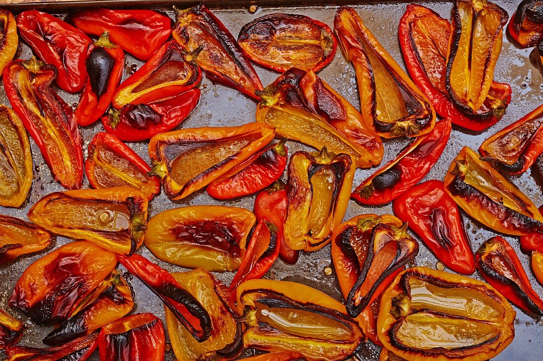 Baked red and yellow peppers on a baking tray