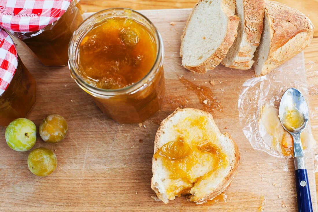 Reineclaudenmarmelade und Brot auf Schneidebrett