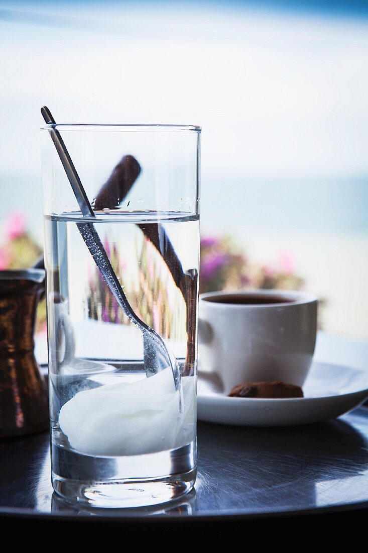 Griechischer Kaffee und Glas mit Süssigkeit auf einem Tisch am Meer