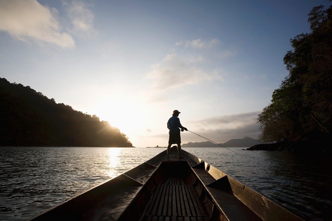 Angler auf einem Boot im Abendlicht