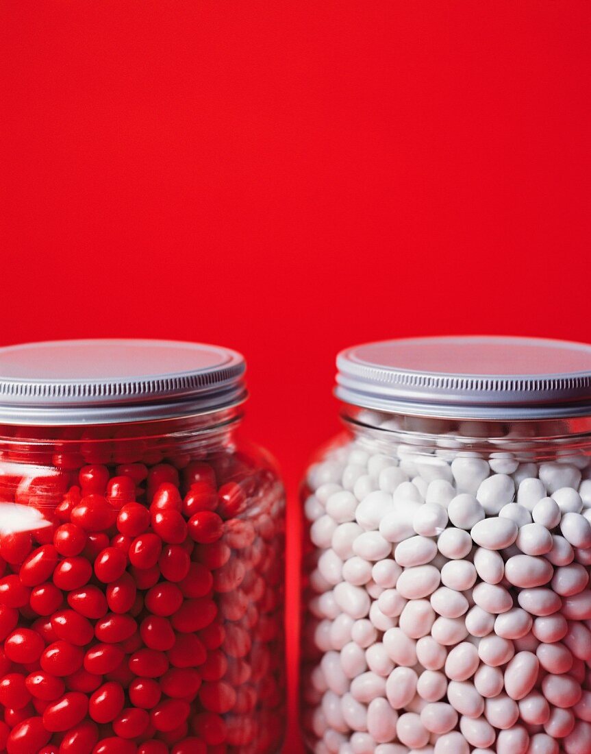 Rote und weiße Jelly Beans in Vorratsgläsern