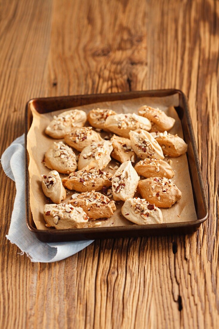 Meringues with cinnamon and nuts on a baking tray