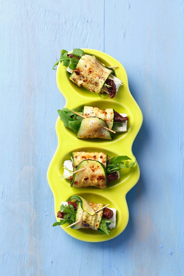 Gegrillte Zucchiniröllchen mit Feta, getrockneten Tomaten und Rucola