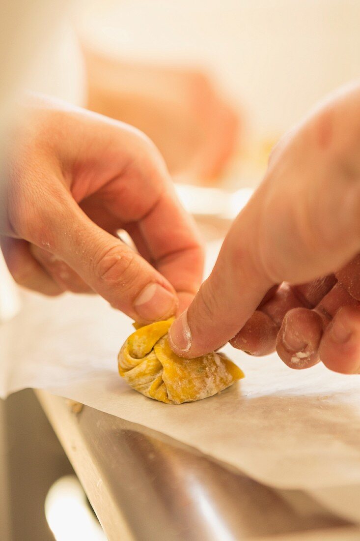A tortellini being folded together