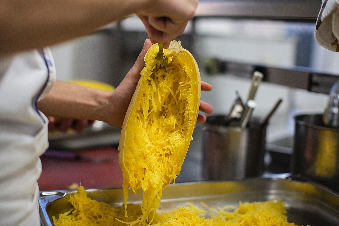 A spaghetti squash being hollowed out