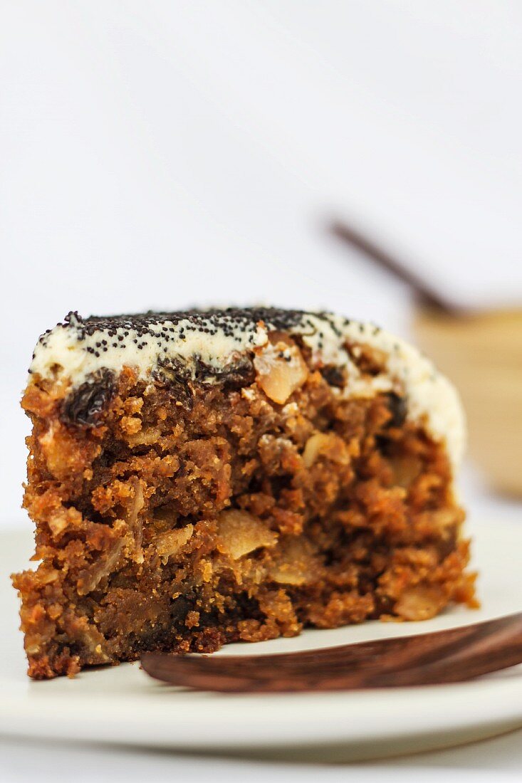 A slice of carrot cake with poppy seeds