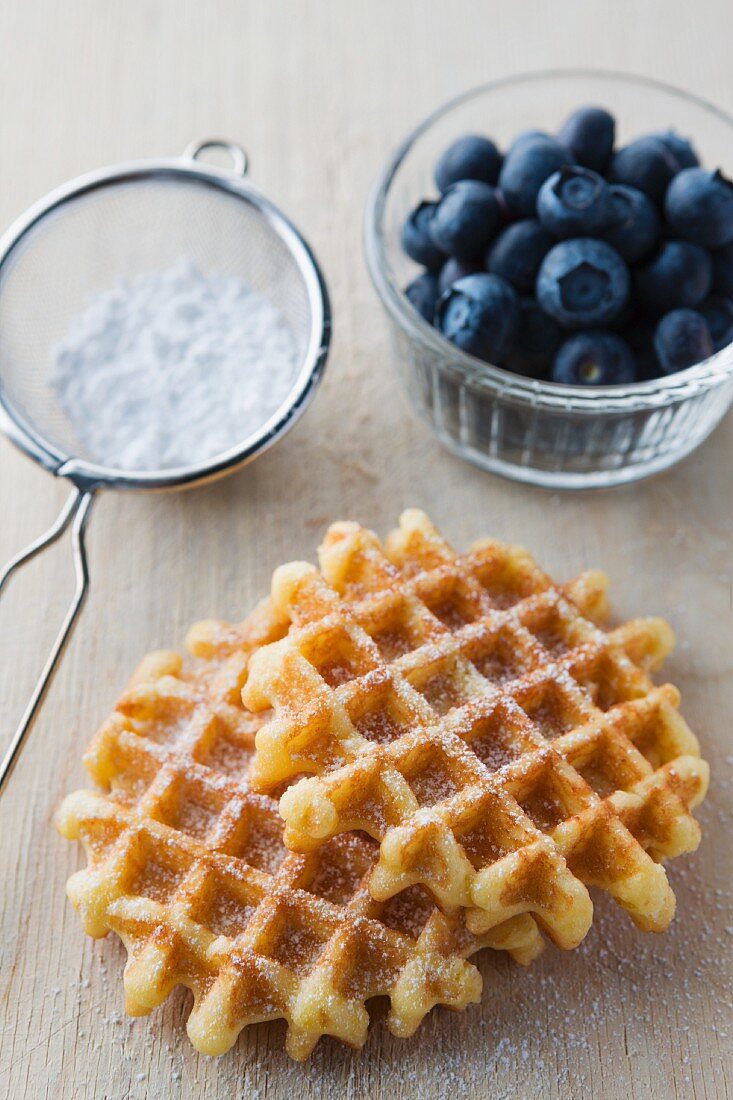 Waffles with icing sugar and fresh blueberries