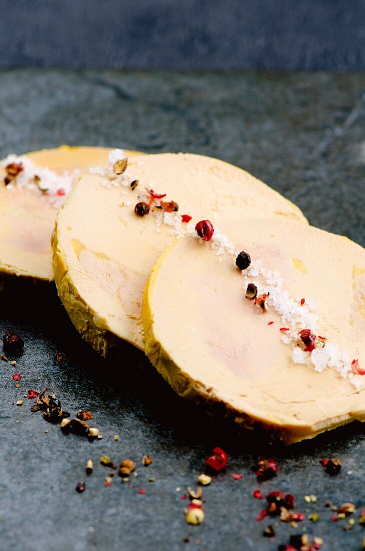 Foie gras on a slate slab with fleur de sel and peppercorns