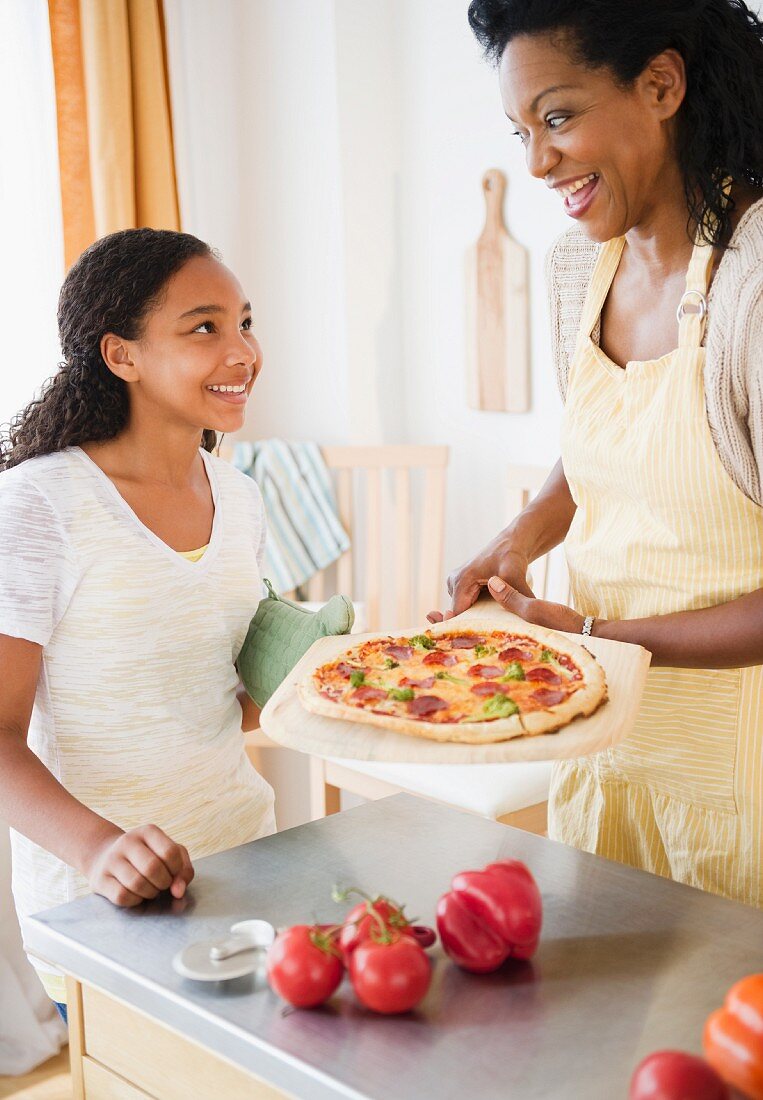 A mother and daughter making pizza