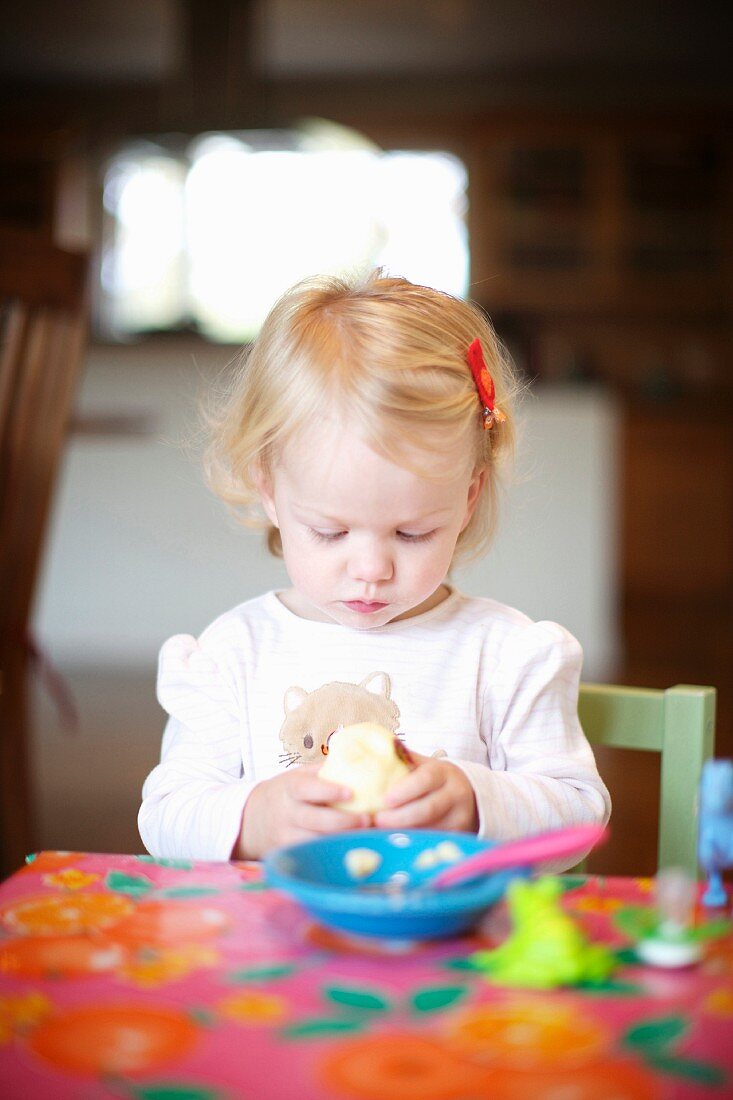 Kleines Mädchen beim Essen am Tisch
