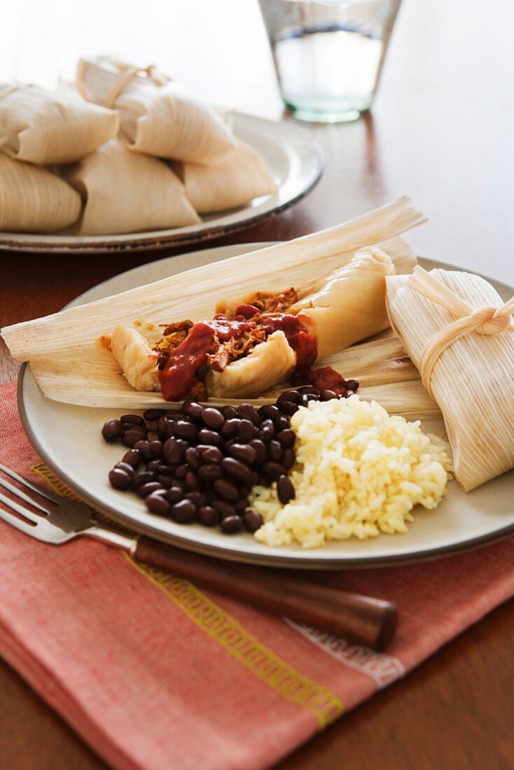 Pamonha (Stuffed corn leaves, Brazil) with beans and rice