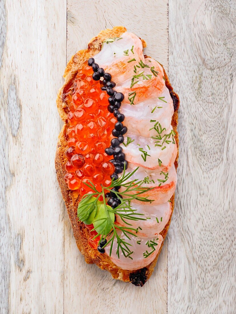A slice of bread topped with fish and caviar