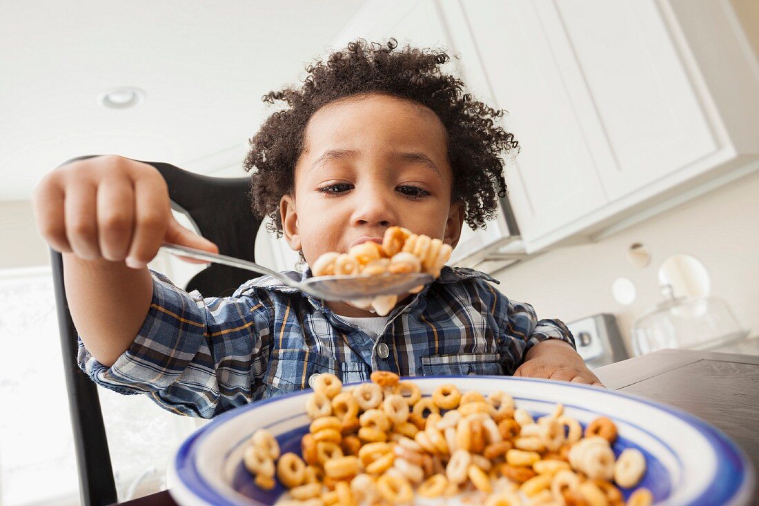 Black boy eating bowl of cereal