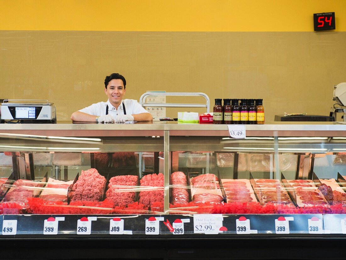 A sales assistant behind a meat counter