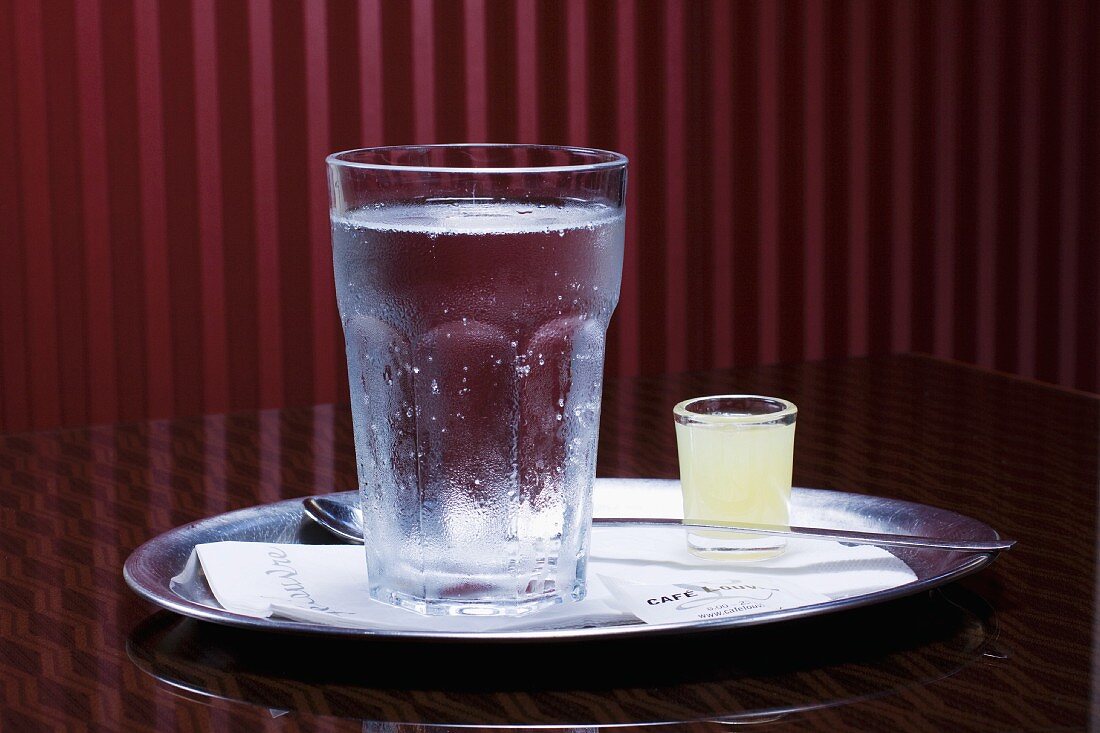 Wasser und Zitronensaft auf Tablett im Café