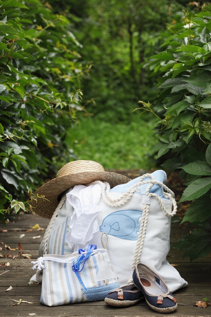 Straw hat on hand-sewn beach bag and cosmetics bag made form striped fabric