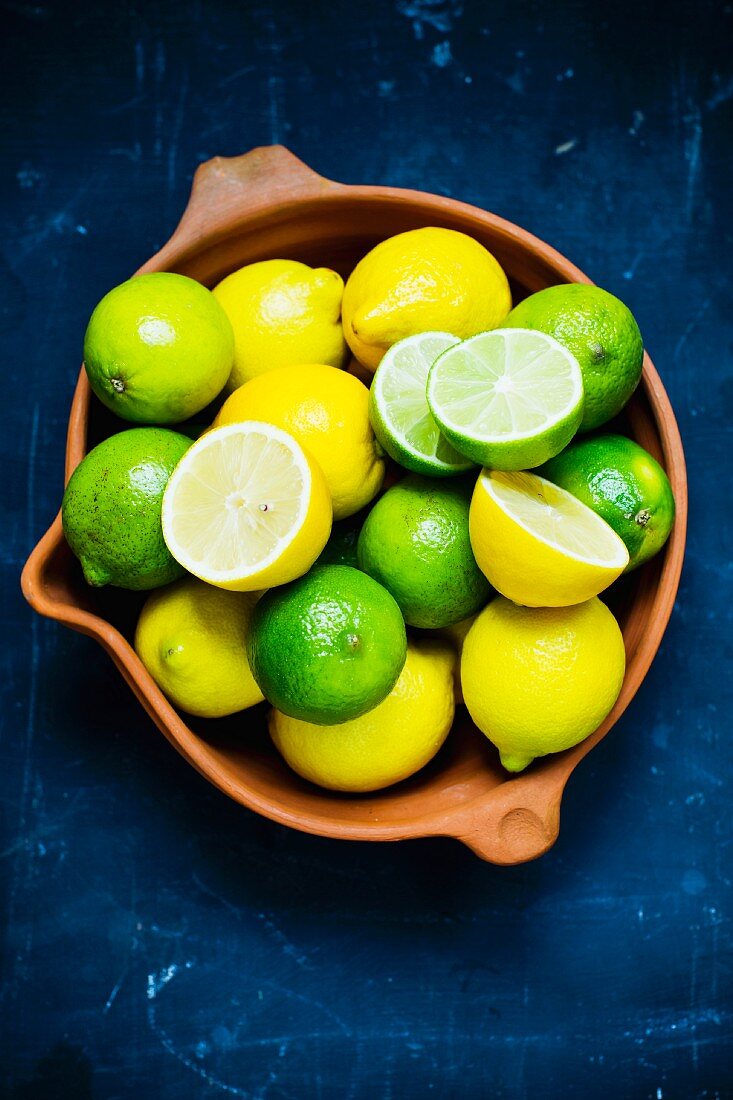 Frische Zitronen und Limetten in einer Tonschale