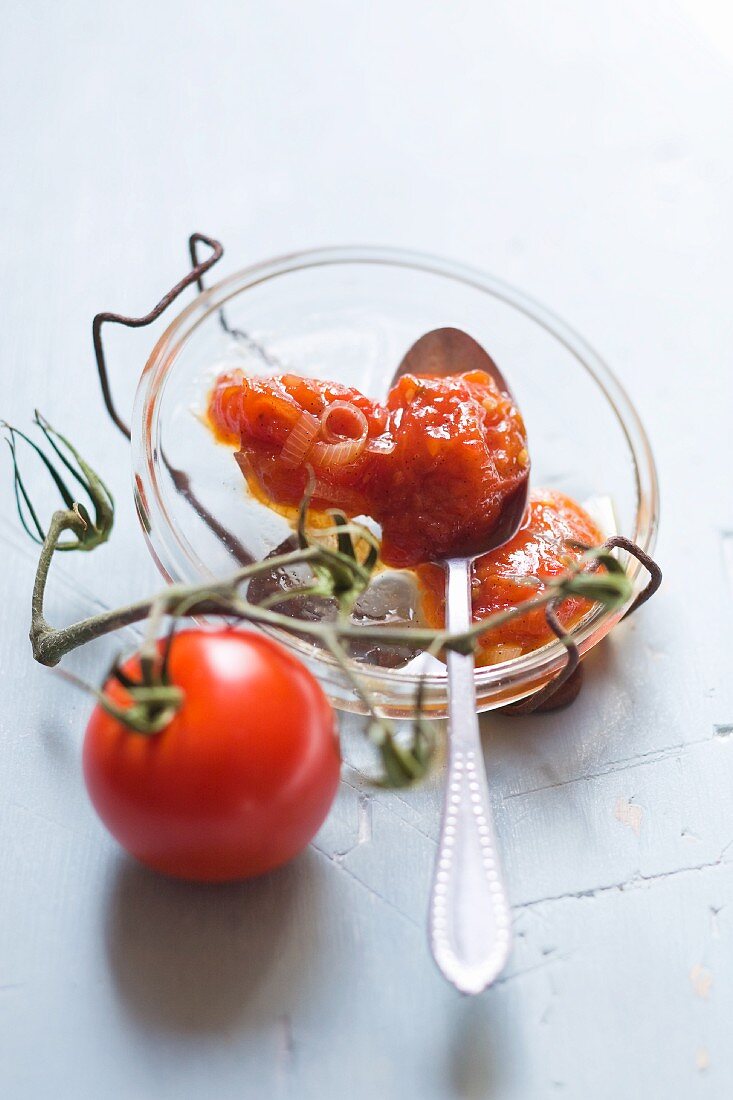 Tomato chutney in a bowl with a spoon